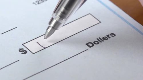 Macro Shot Of A Hand Writing A Check
