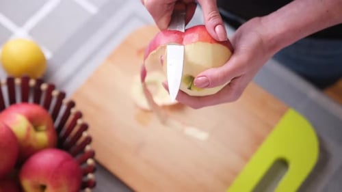 Hands Peeling Apple with Knife Close Up