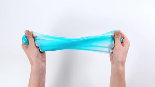 Playing with slime, stretching the gooey substance for fun and stress relief.