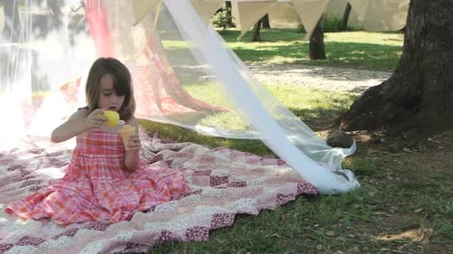 Girl Blowing Bubbles in Tent in Yard