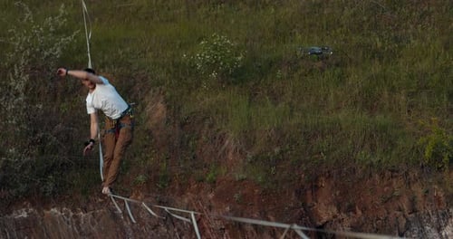 Athletic Man Walking Highline Tightrope on Cliff
