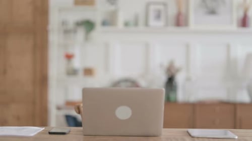 Young Man Coming Back Opening Laptop in Office