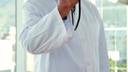 Doctor Holds Stethoscope Forward in Examination Room