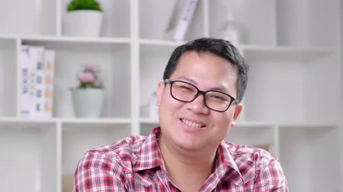 Man Talking and Gesturing Indoors with a Smile