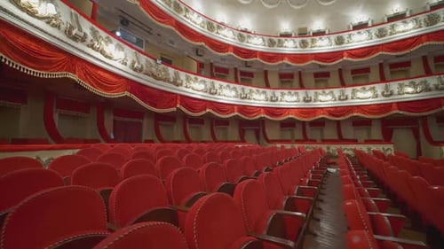 Rows of red chairs in theater hall.