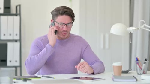Man Talking on Phone in Office Setting