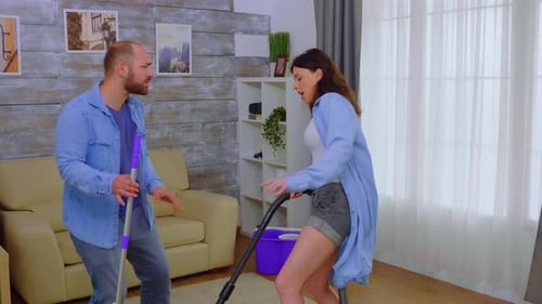 Couple Cleaning and Singing in Living Room