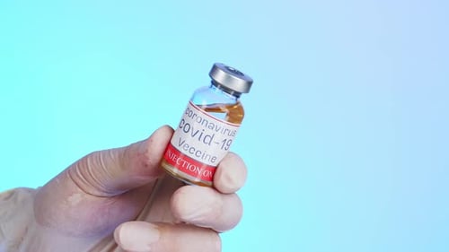 COVID-19 Vaccine Vial Held by a Hand
