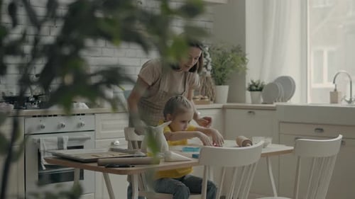 Mother and Child Baking Cookies Together in Kitchen