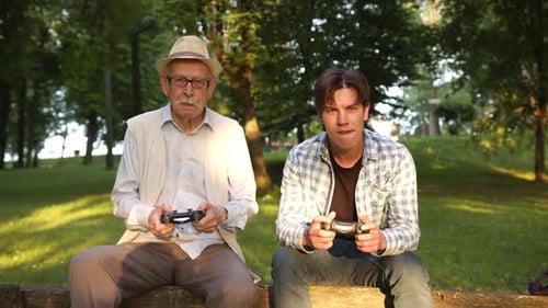 Senior Man and Young Adult Play Video Games