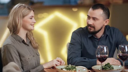 Happy Couple Talking Smiling During Dinner Enjoying Date at Restaurant