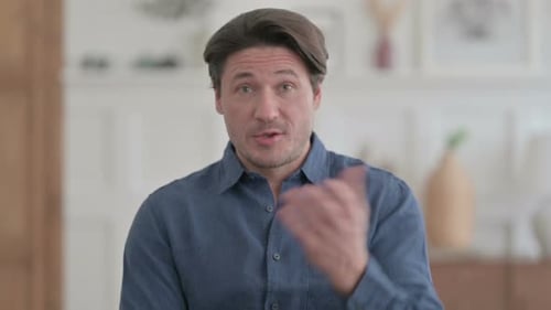 Man Speaking and Gesturing in Clean Interior Setting