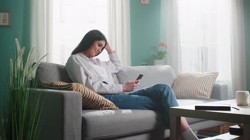 Woman Relaxing at Home Looking at Phone