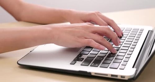 Typing on notebook computer at home