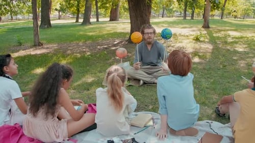 Schoolchildren Learning about Solar System in Park