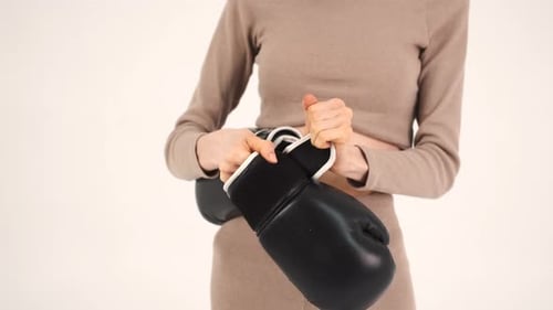 Woman Putting on Black Boxing Gloves Close Up
