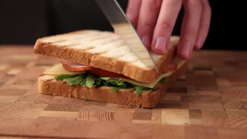 Cutting a Delicious Sandwich on a Wood Board