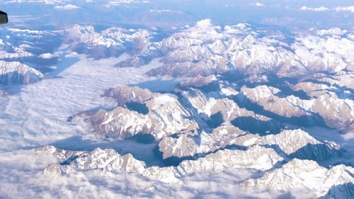 Beautiful View Through Airplane Window, Airplane Flying Above Mountains with Clouds