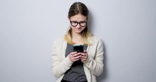 Smiling Woman Types on Phone Indoors