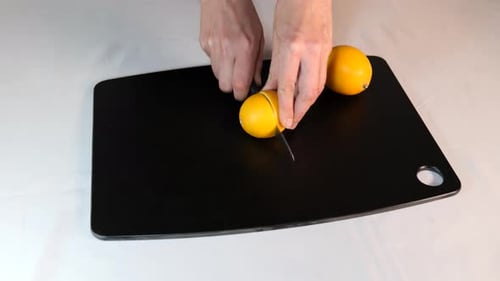 Mujer cortando limones frescos en la pizarra