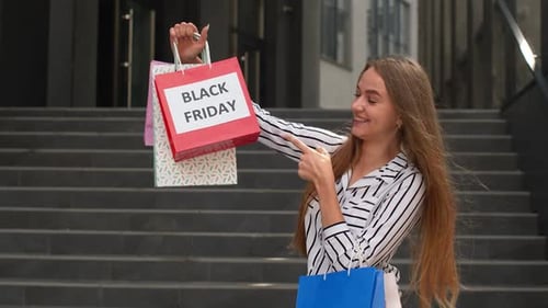 Girl Walking and Showing Black Friday Inscription on Shopping Bags, Rejoicing Discounts in Store