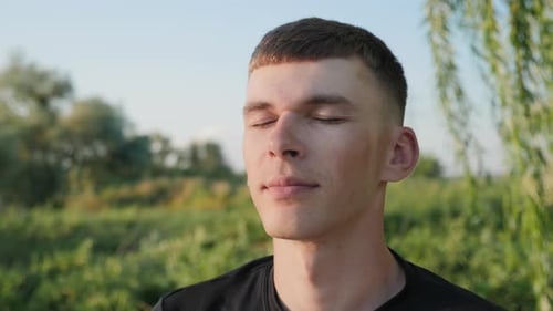Young Adult Man Relaxing Outside With Eyes Closed