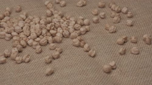 Dried Chickpeas Scattered on Rustic Burlap Background