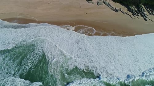 Vue aérienne sur les vagues de l'océan et la plage de sable
