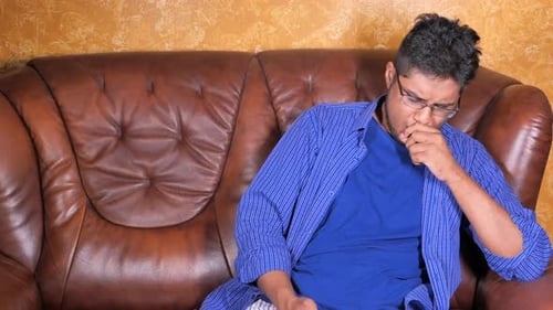Man on Couch Experiencing Chest Pain