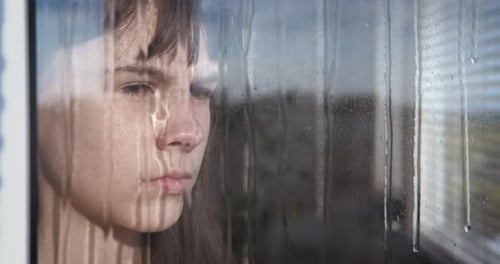 Teen Looking Out Rainy Window Close-Up