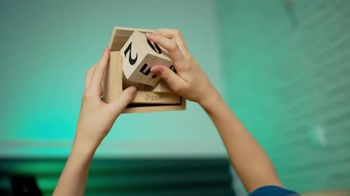Hands Changing Wooden Block Calendar Dates