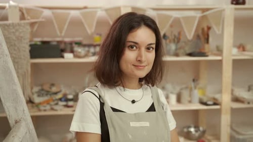 Smiling Craftswoman in Pottery Workshop
