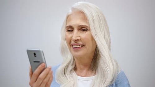 Senior Woman Scrolling Online Indoors
