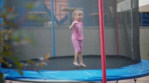 Girl Jumps on Trampoline Outside