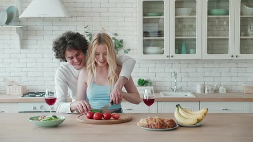 Smiling Couple Preparing Food Together in Kitchen