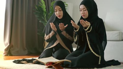Muslim Women Praying Indoors in Traditional Dress