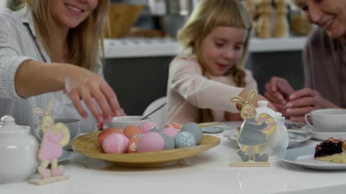 Family Decorating Easter Eggs Together at Home