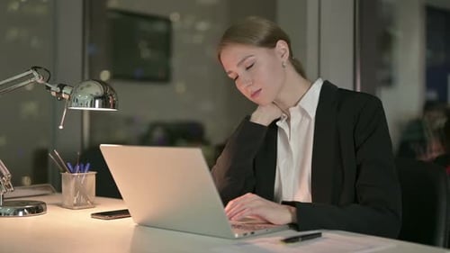 Tired Businesswoman Having Neck Pain in Office at Night