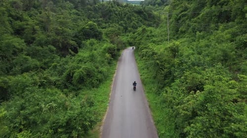 Aerial View Of Motorbike Riding On Road Cross The Forest