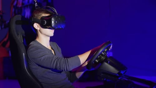Jeune homme jouant dans le simulateur de conduite automobile