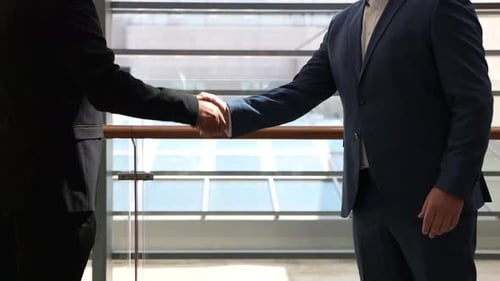 Businessmen Shake Hands in Modern Office Building