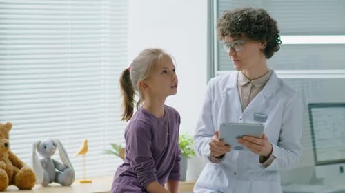 Girl and Doctor Viewing a Tablet Together