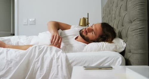 Man Waking Up and Reaching For Mobile Phone