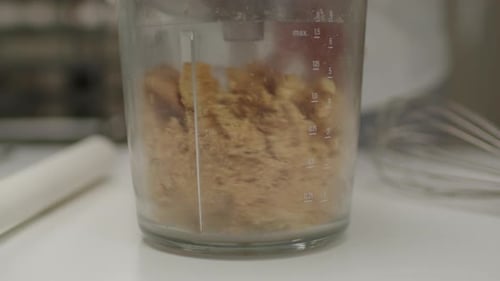 Grinding shortbread cookies in a blender for cheesecake base. Slow motion.