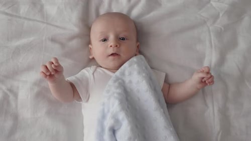 Adorable Baby Lying on White Blanket