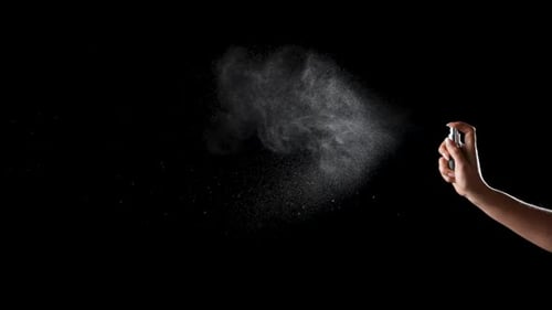 Damenhandfinger-Sprays Parfüm auf schwarzem Hintergrund