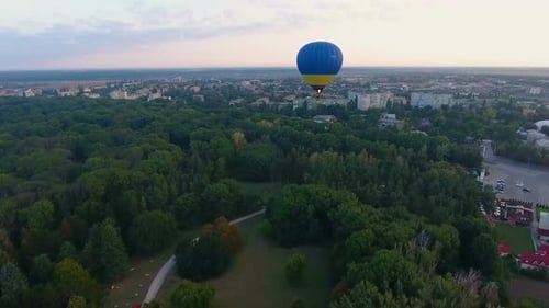 Hot Air Balloon Floating Over City Park in Early Morning, Rising up Into Sky