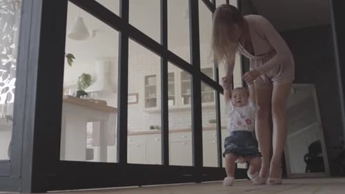 Mother Helps Baby Take First Steps at Home