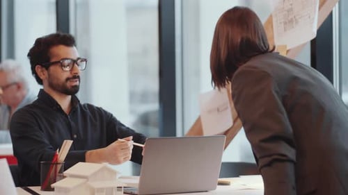 Architects Reviewing Building Plans in Modern Office