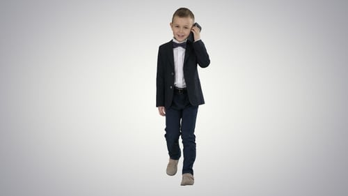 Boy in Suit Walks and Talks on Cellphone